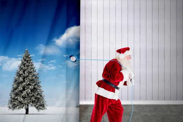 Composite image of santa claus pulling rope — Stock Photo, Image