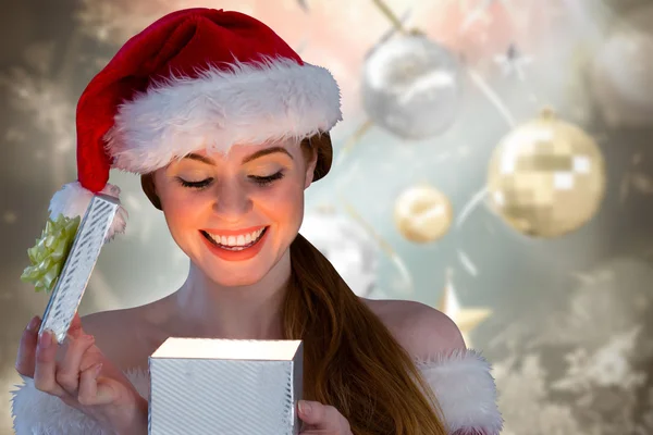 Immagine composita di ragazza sexy in costume da Babbo Natale che apre un regalo — Foto Stock