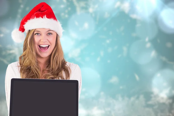 Samengestelde afbeelding van feestelijke blonde met een laptop — Stockfoto