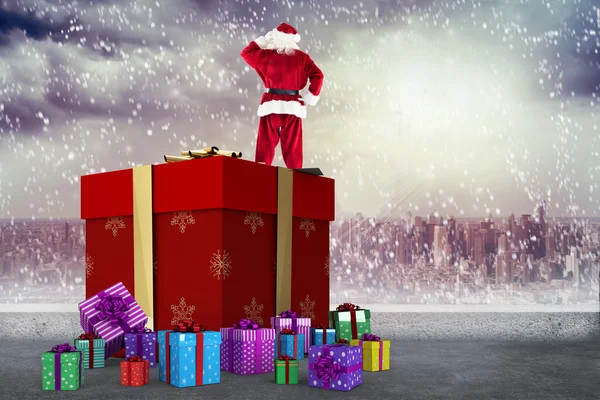 Composite image of santa standing on giant present — Stock Photo, Image