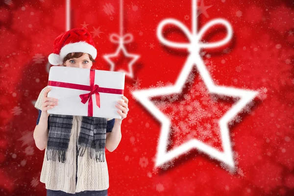 Imagen compuesta de una mujer sosteniendo un regalo de Navidad —  Fotos de Stock