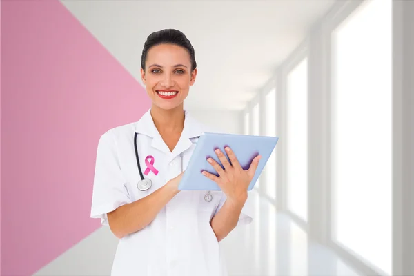 Composite image of pretty nurse using tablet pc — Stock Photo, Image