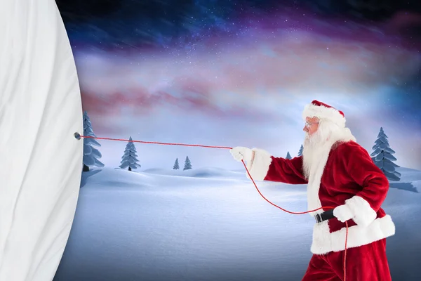 Santa claus pulling a rope — Stock Photo, Image