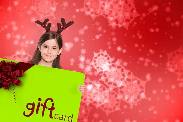 Imagem composta de menina festiva mostrando cartão — Fotografia de Stock