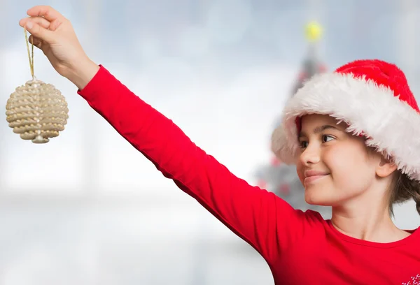 Composite image of festive girl hanging decoration — Stock Photo, Image