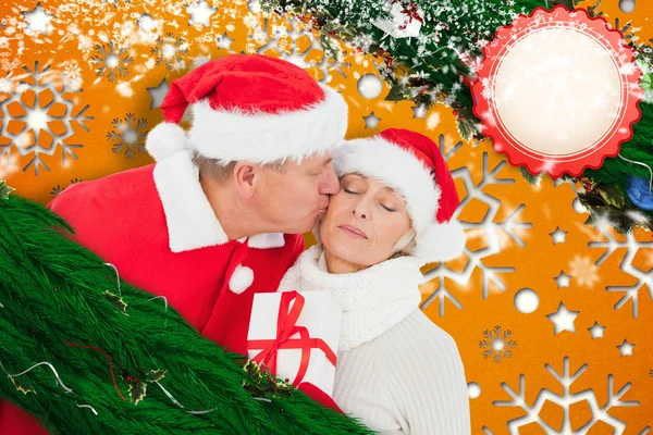 Imagen compuesta de pareja madura festiva sosteniendo regalo — Foto de Stock