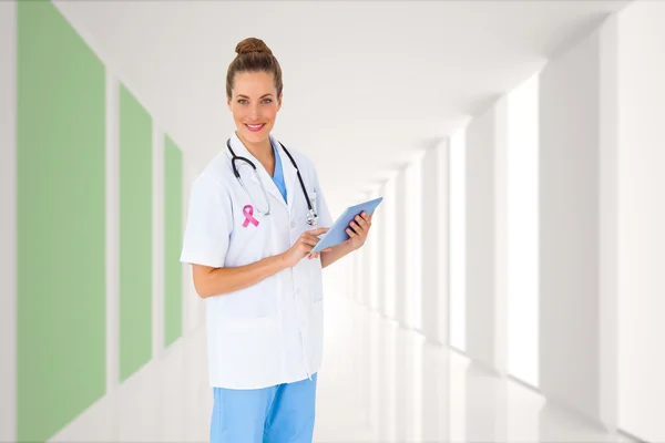 Composite image of pretty nurse using tablet pc — Stock Photo, Image