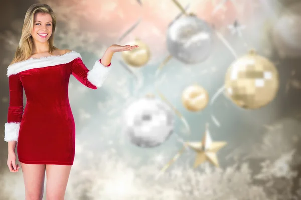 Composite image of pretty girl presenting in santa outfit Stock Photo