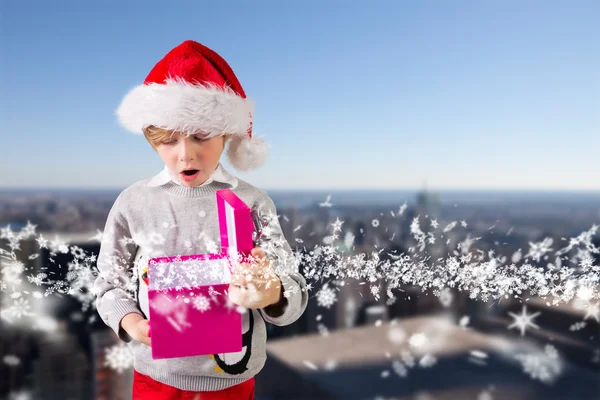 Imagem composta de menino festivo segurando um presente — Fotografia de Stock