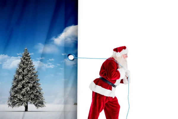 Composite image of santa claus pulling rope — Stock Photo, Image