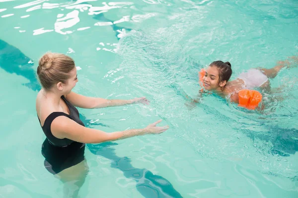 Милая маленькая девочка учится плавать с тренером — стоковое фото