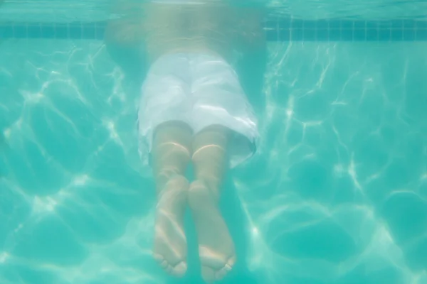 Niño lindo posando bajo el agua en la piscina — Foto de Stock