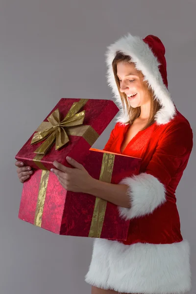 Vackra santa flicka öppnar en gåva — Stockfoto