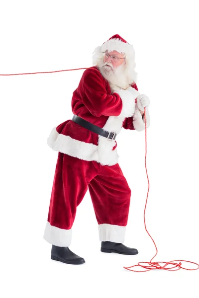 Santa pulling something with rope — Stock Photo, Image