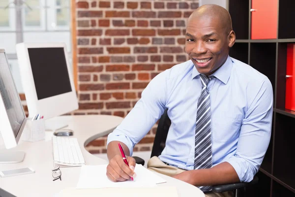 Businessman writing document at office desk — Stock Photo, Image