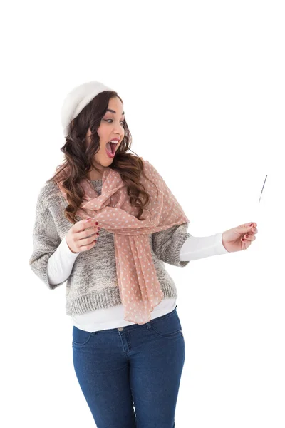 Pretty brunette in winter clothes holding fireworks — Stock Photo, Image