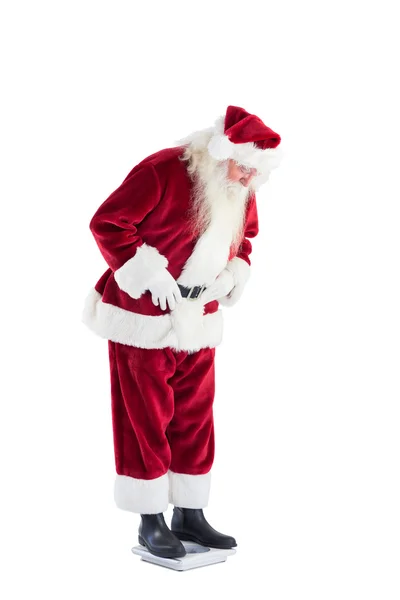 Weihnachtsmann blickt auf persönliche Waage — Stockfoto