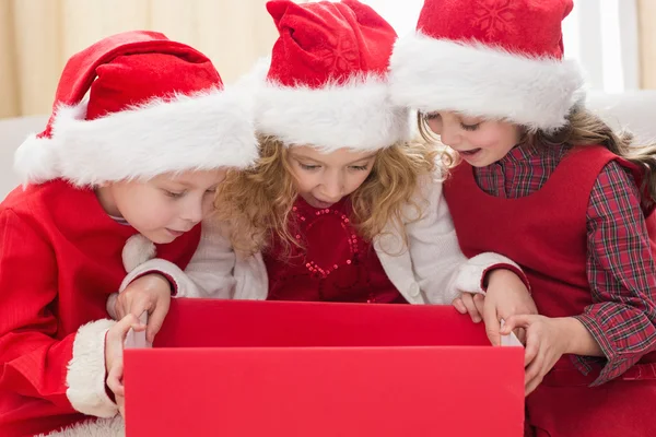 Pequeños hermanos festivos mirando el regalo —  Fotos de Stock