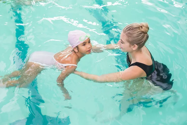 Cute little girl learning to swim with coach — Stock Photo, Image