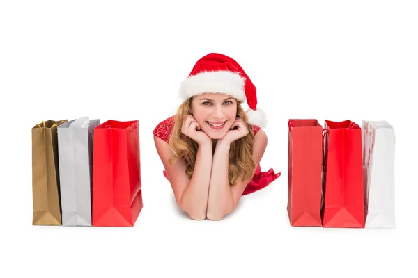 Mulher sorridente deitada entre sacos de compras — Fotografia de Stock