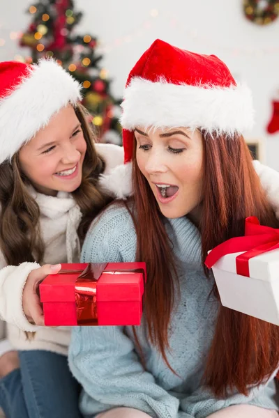 Festive mother and daughter exchanging gifts — Stock Photo, Image