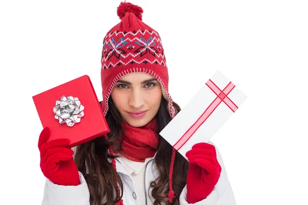 Festive brunette in winter clothes showing gifts — Stock Photo, Image