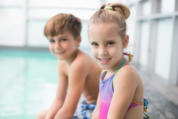 Roztomilý malý sourozenci sedět u bazénu — Stock fotografie