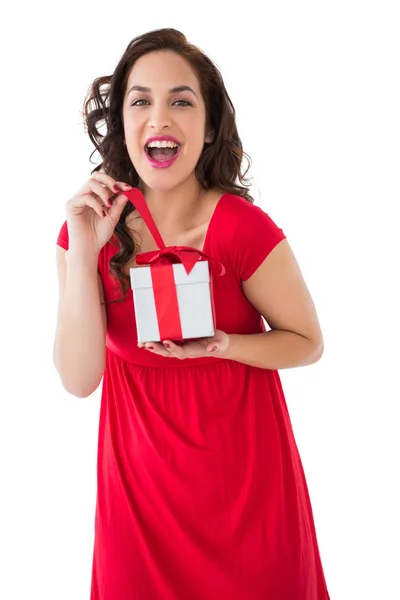 Podekscytowany brunetka otwierając prezent na Boże Narodzenie — Zdjęcie stockowe