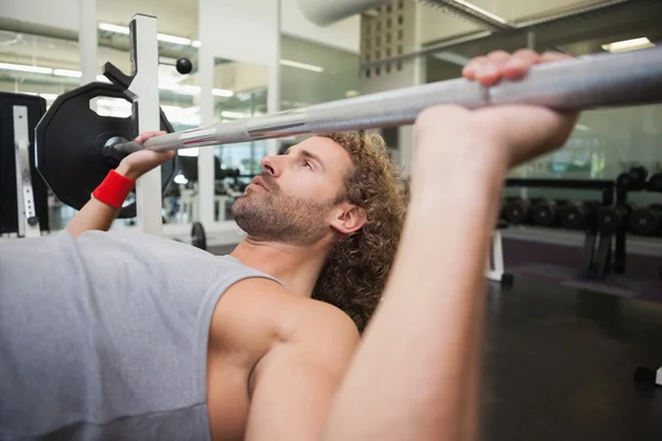 Homme levant haltère dans la salle de gym — Photo