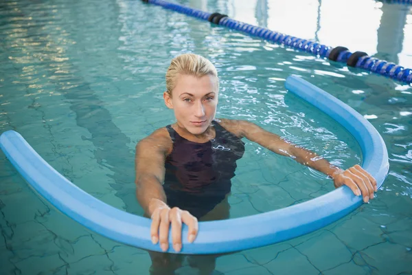 Kvinna som simma med foam roller i pool — Stockfoto