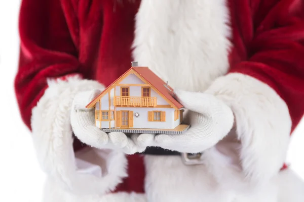 Santa holds a tiny house in his hands — Stock Photo, Image