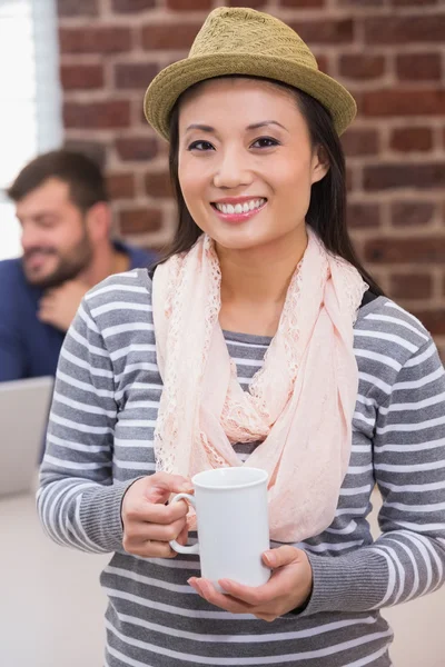 Casual woman with coffee cup in office — Stock Photo, Image