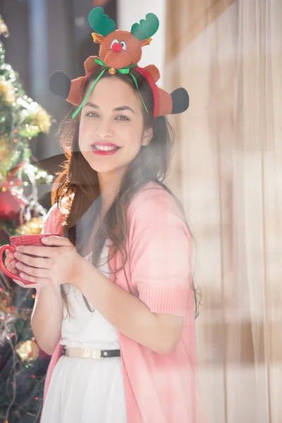Brünette mit Weihnachtsmütze und Tasse — Stockfoto