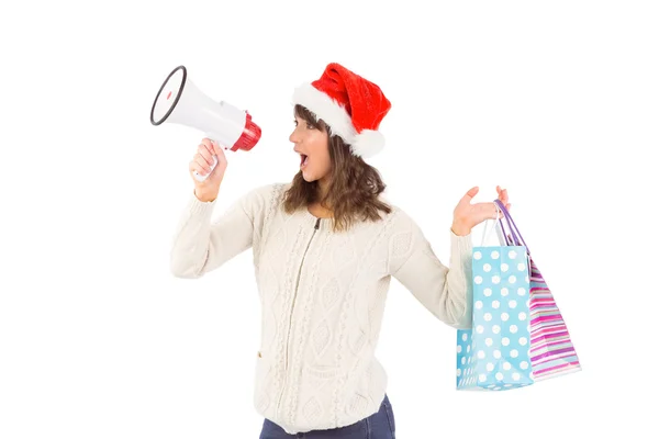 Festive brunette holding megaphone and bags — Stock Photo, Image