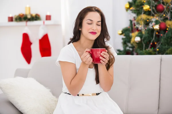 Söt brunett njuter av en varm dryck på jul — Stockfoto