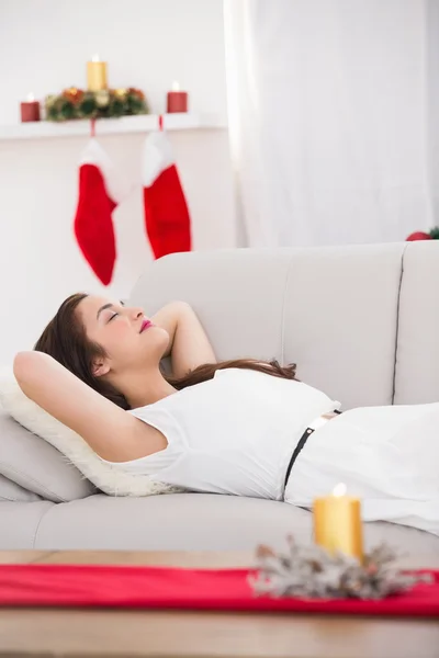Morena relaxada deitada no sofá no Natal — Fotografia de Stock