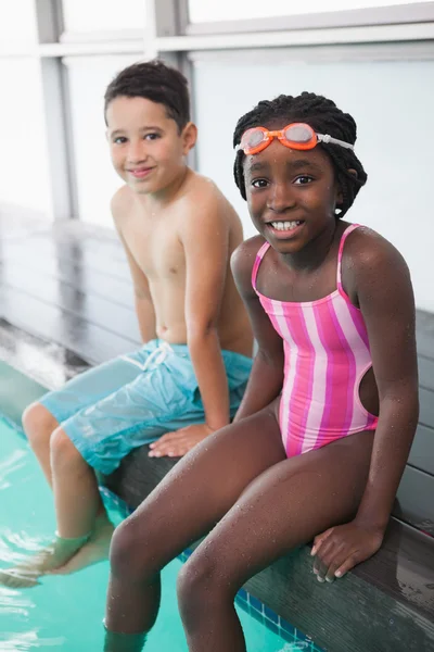 Bambini piccoli seduti a bordo piscina — Foto Stock