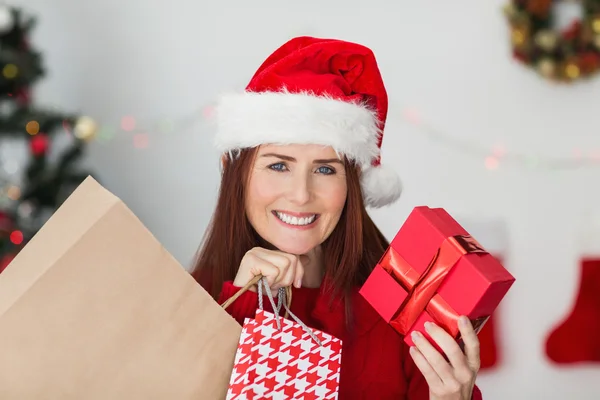 Festive redhead holding christmas gifts — Stock Photo, Image