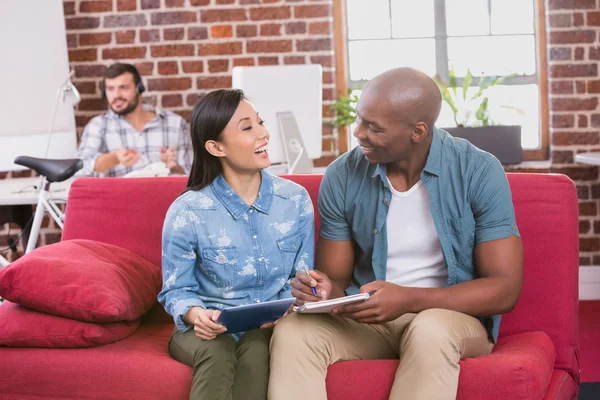 Colleagues using digital tablet on couch — Stock Photo, Image