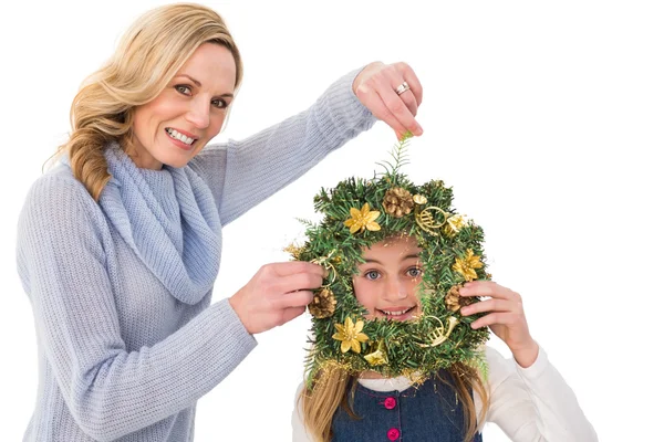 Madre e hija festiva sosteniendo corona de Navidad — Foto de Stock