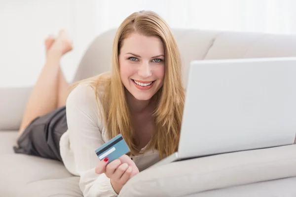 Blondine shoppt online auf der Couch liegend — Stockfoto