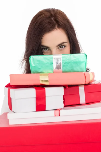 Portrait of a brunette holding pile of gifts — Stock Photo, Image