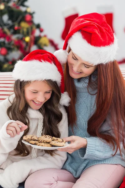 Madre e hija festiva en el sofá con galletas —  Fotos de Stock