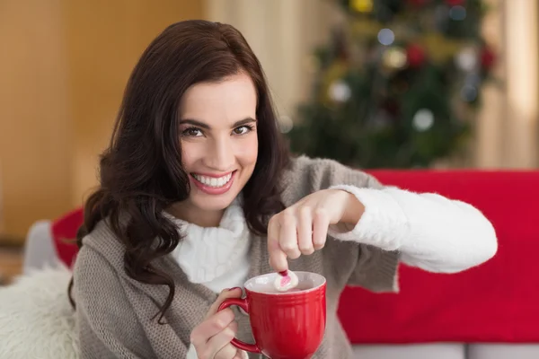 Brunette dunking marshmallow in warme chocolademelk met Kerstmis — Stockfoto