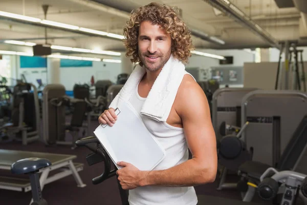 Handsome trainer with clipboard in gym — Stock Photo, Image