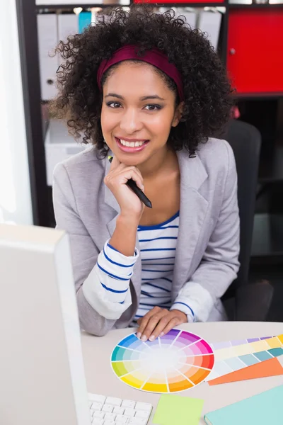 Smiling female photo editor at office desk — Stock Photo, Image