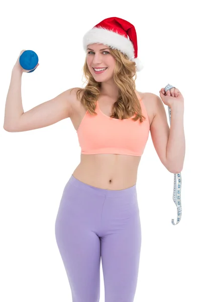 Smiling fit blonde holding dumbbell and measuring tape — Stock Photo, Image