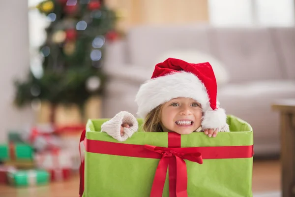 Niedliches kleines Mädchen sitzt in riesigen Weihnachtsgeschenk — Stockfoto