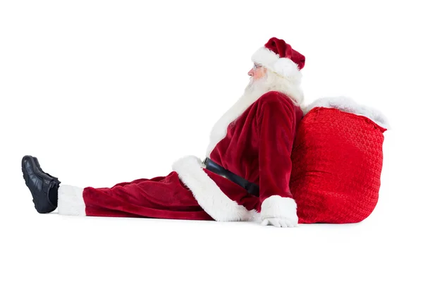 Santa se sienta apoyado en su bolso — Foto de Stock