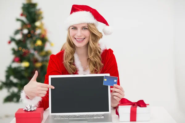 Festlig blondin handla online med laptop och pekar på det — Stockfoto